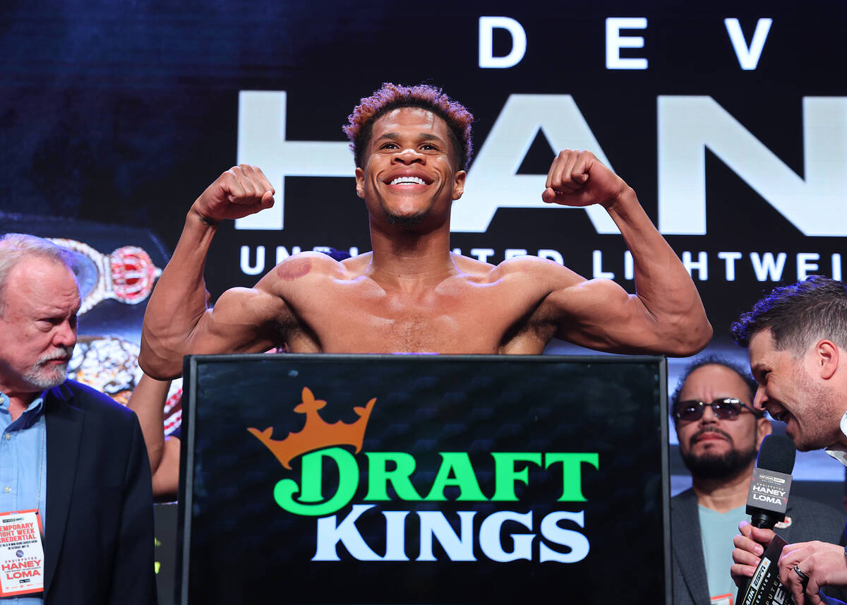 Devin Haney flexes on the scale during the weigh in ahead of his May 20 Undisputed lightweight ...