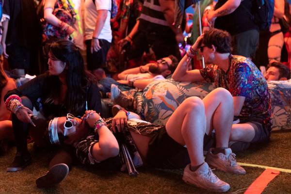 Attendees rest during the second day of electronic dance music festival Electric Daisy Carnival ...
