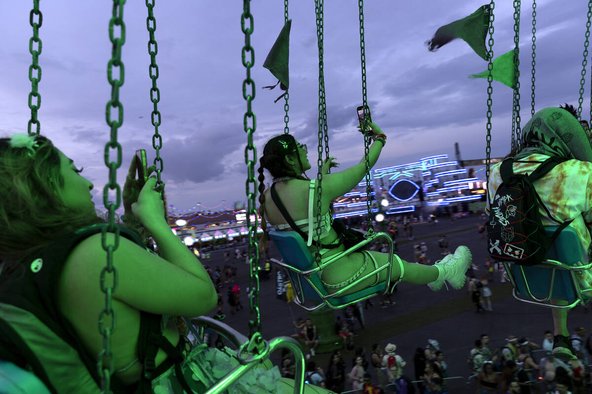 Attendees take selfies on the swings during the second day of electronic dance music festival E ...
