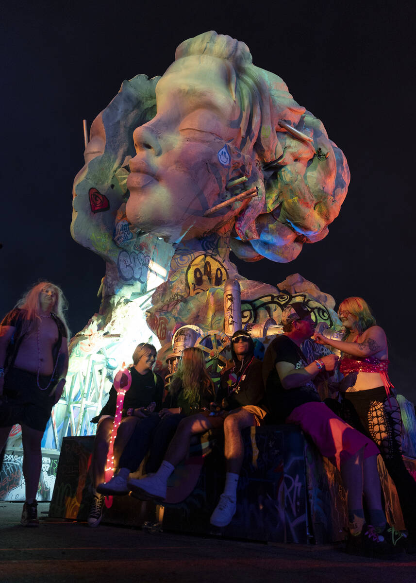 Attendees rest on an art installation during the second day of electronic dance music festival ...