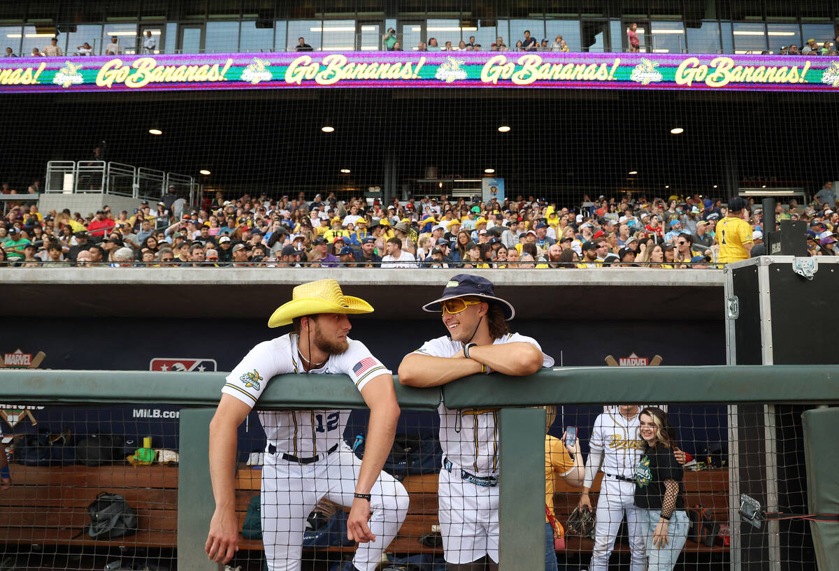 Savannah Bananas’ Kyle Luigs, left, and Christian Dearman interact in the dugout before ...