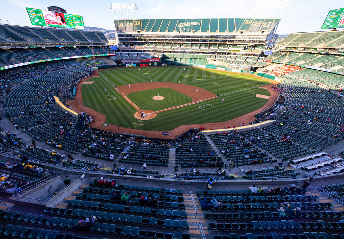 Fans watch a baseball game between the A’s and the Cincinnati Reds at the at Oakland Coliseum ...