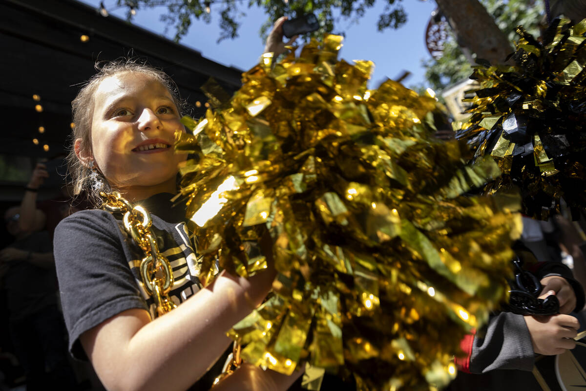 Kennedy Livingston, 7, cheers as a parade lead by the Golden Knights Ice Crew and Drum Line hea ...
