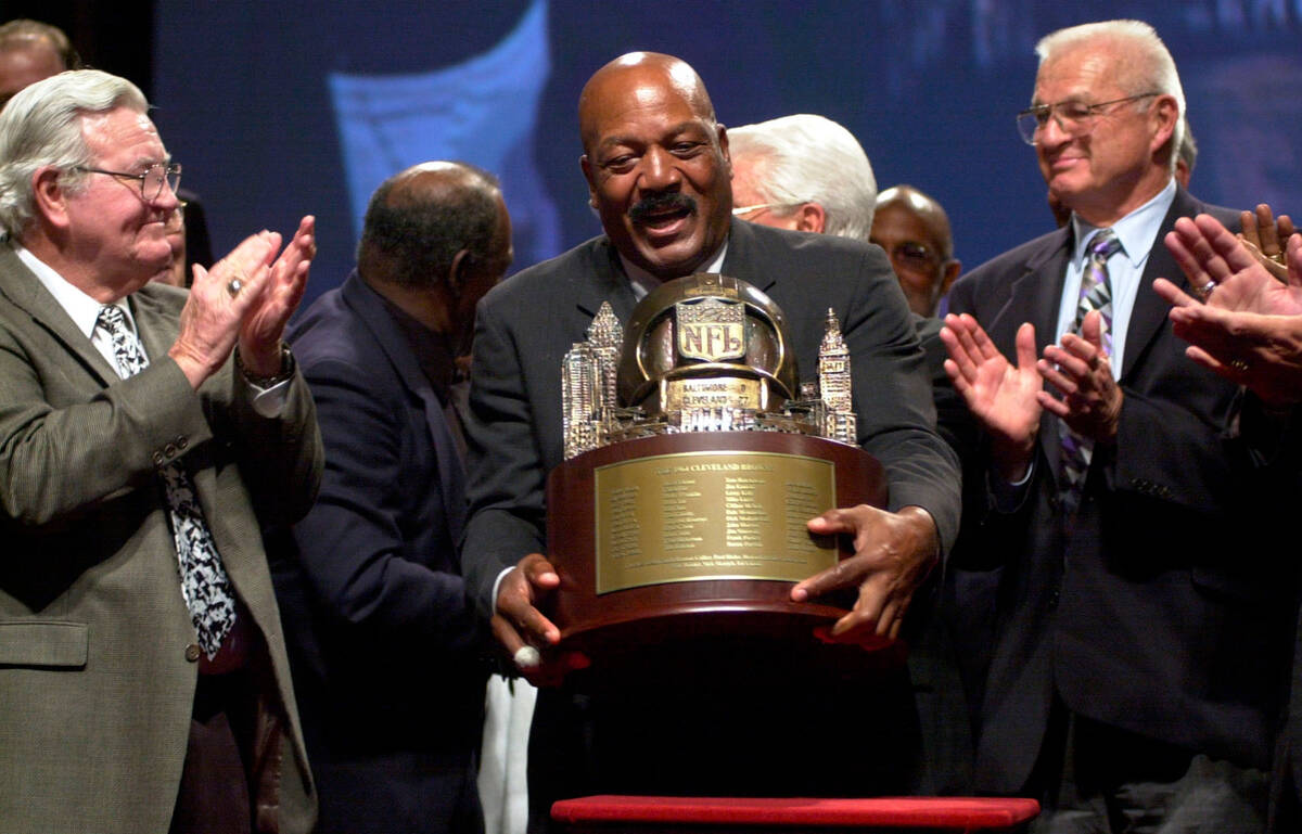 FILE - Jim Brown, center, picks up a trophy presented by NFL Commissioner Paul Tagliabue, to th ...
