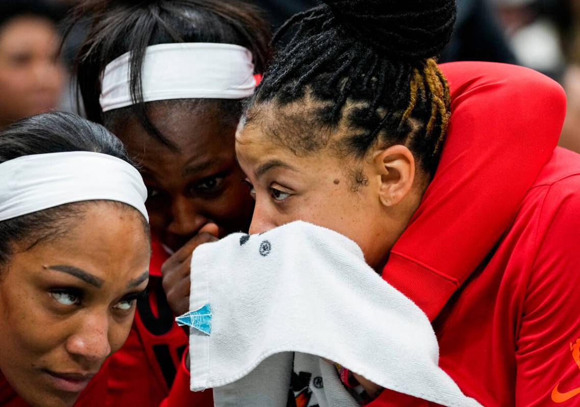 Las Vegas Aces forward A'ja Wilson, left, leans in to talk with guard Chelsea Gray, center, and ...