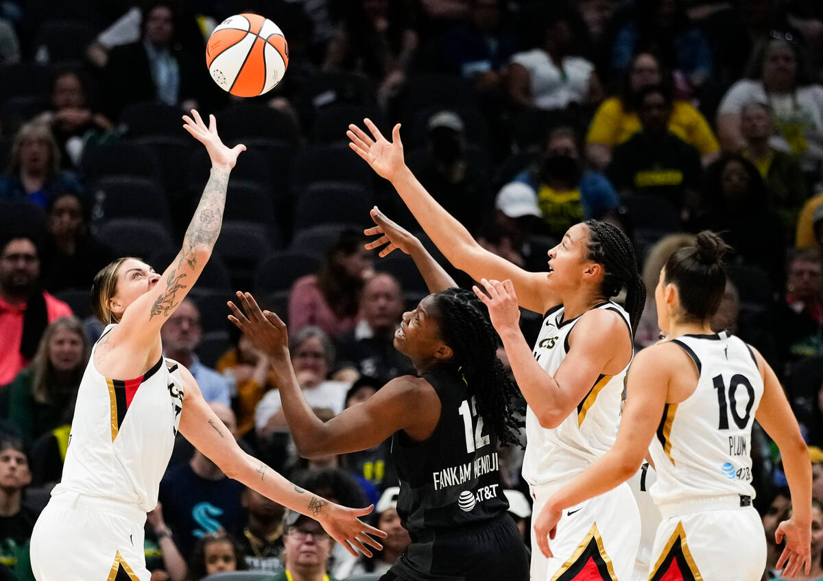 Las Vegas Aces forward Cayla George, left, tips the ball away from Seattle Storm forward Dulcy ...