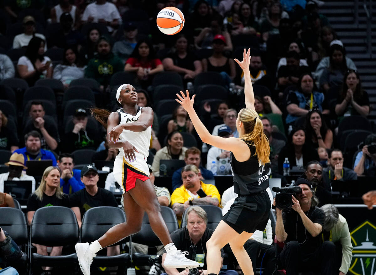 Las Vegas Aces guard Jackie Young (0) throws a pass over Seattle Storm guard Ivana Dojkic (18) ...