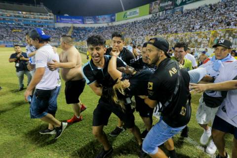 An injured fan in carried to the field of Cuscatlan stadium in San Salvador, El Salvador, Satur ...