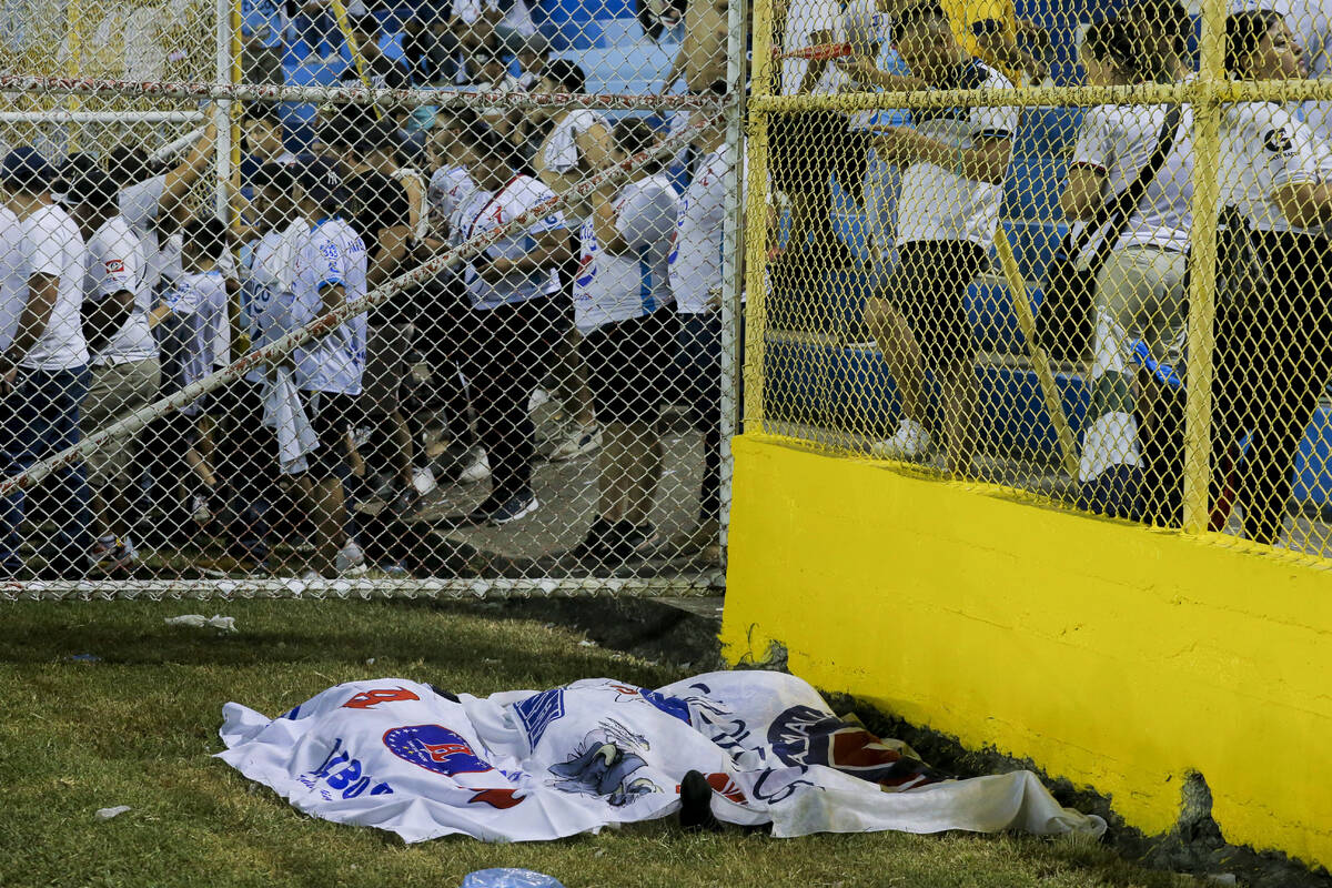 Bodies are covered with a blanket at the field of Cuscatlan stadium in San Salvador, El Salvado ...