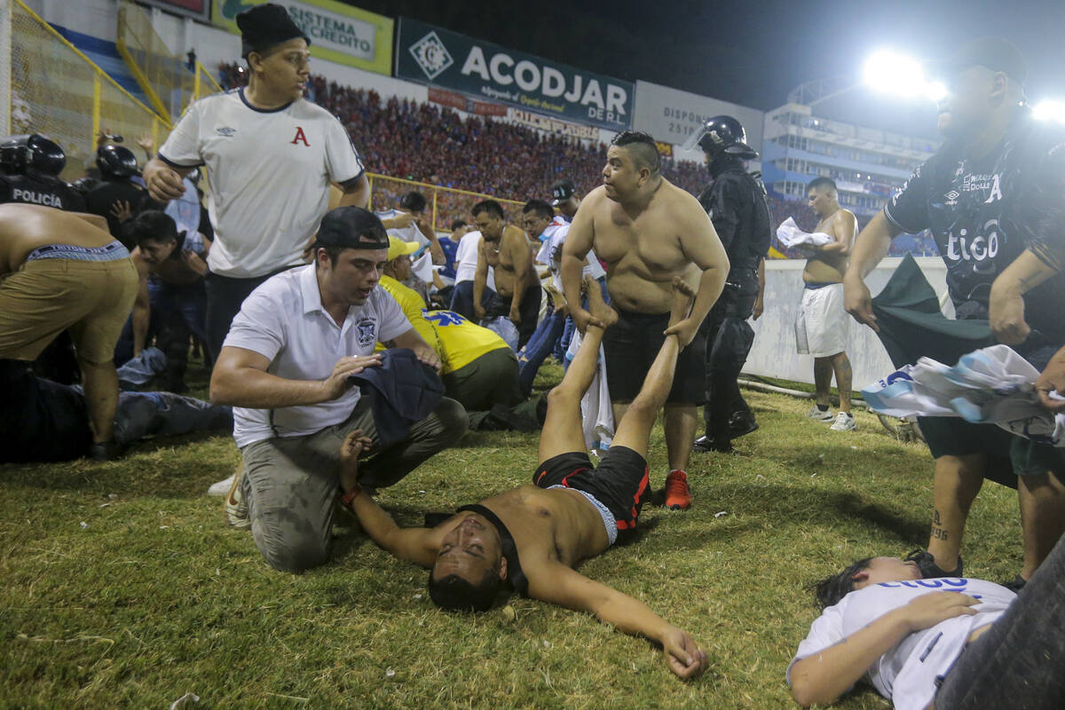 Soccer fans are assisted by others fans at the field of the Cuscatlan stadium in San Salvador, ...