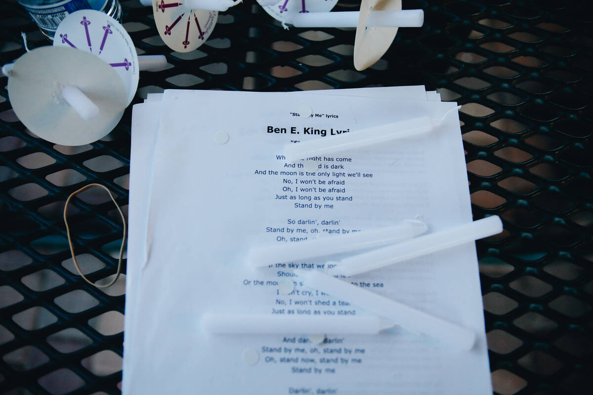 Vigil candles and paper with lyrics to the song “Stand by Me” by Ben E. King are ...