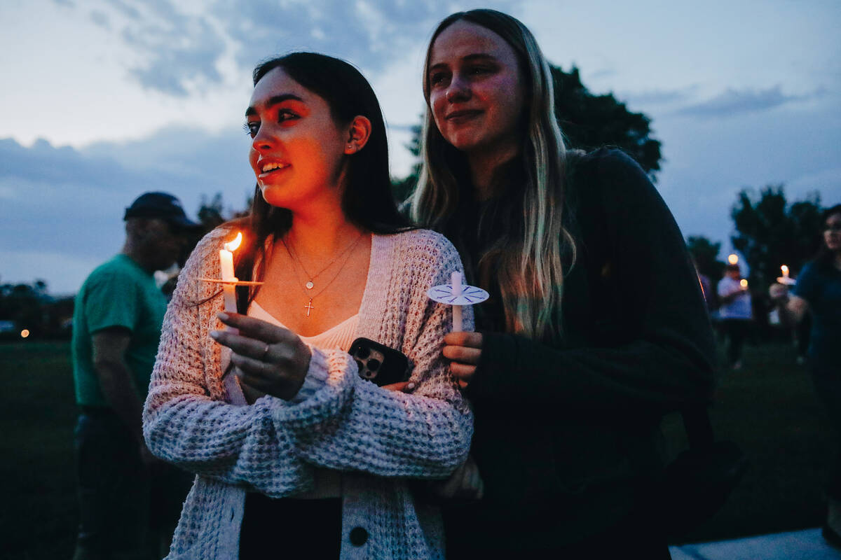 Riley Rodriguez, left, stands close to Lindsey Anderson as they watch motorcyclists ride around ...