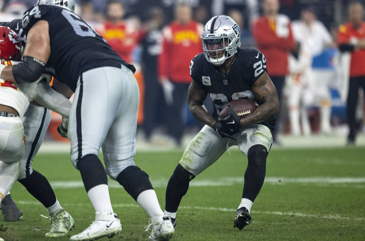 Raiders running back Josh Jacobs (28) looks for room to run against the Kansas City Chiefs duri ...