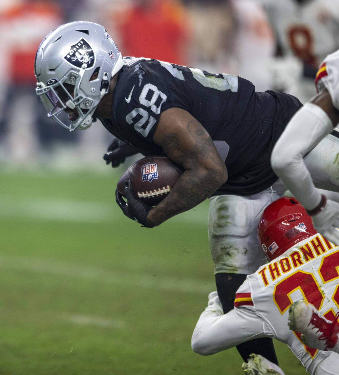 Kansas City Chiefs safety Juan Thornhill (22) wraps up Raiders running back Josh Jacobs (28) du ...