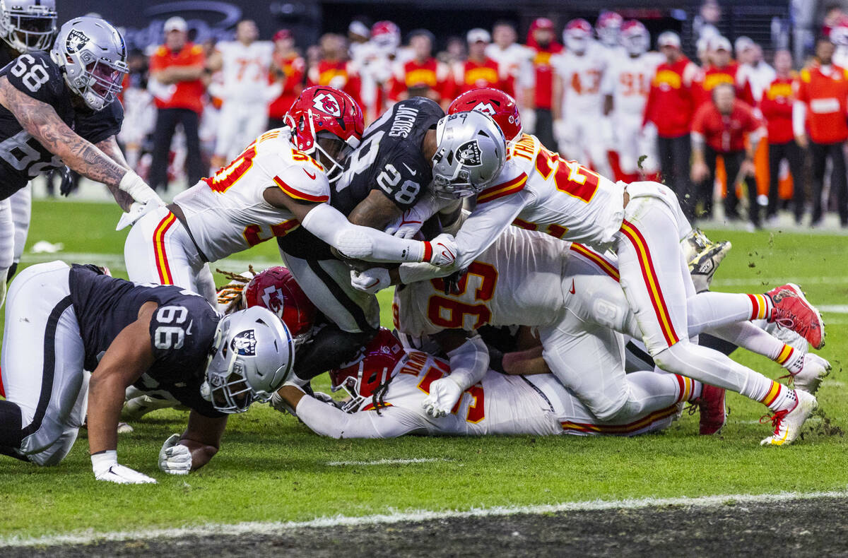 Raiders running back Josh Jacobs (28) battles to get to the end zone versus Kansas City Chiefs ...