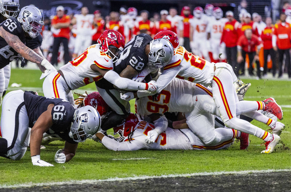 Raiders running back Josh Jacobs (28) battles to get to the end zone versus Kansas City Chiefs ...