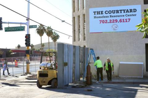 Workers install a gate at the corner of Las Vegas Boulevard and Foremaster Lane near the Courty ...