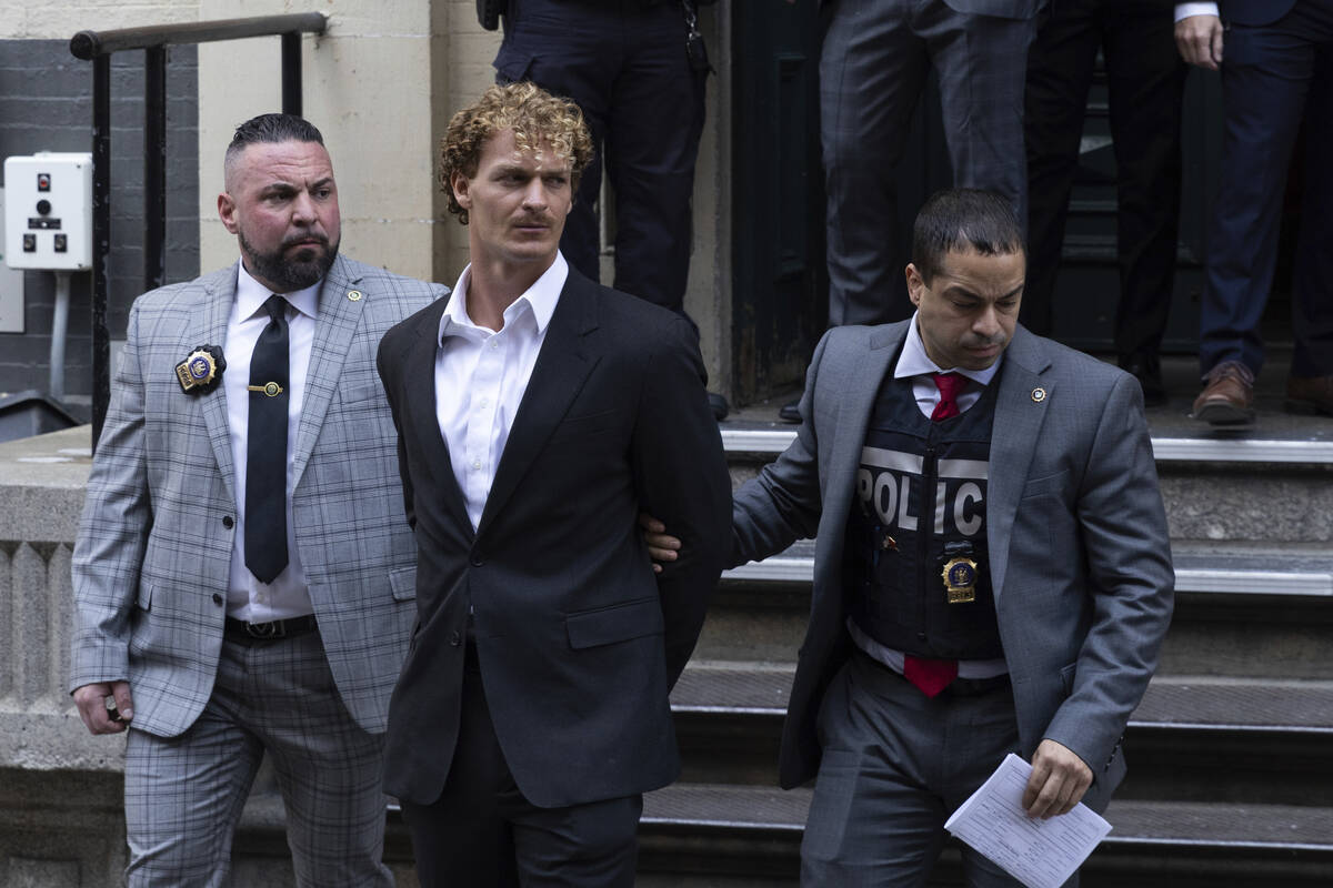 Daniel Penny, center, is walked by New York Police Department detectives detectives out of the ...