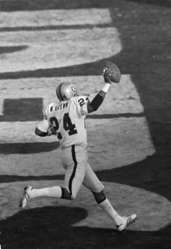 FILE - Oakland Raiders defensive back Willie Brown displays the ball as he strides through the ...