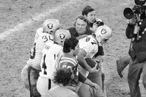 Oakland Raiders' head coach John Madden, upper left, pats tight end Dave Casper, 87, on the bac ...