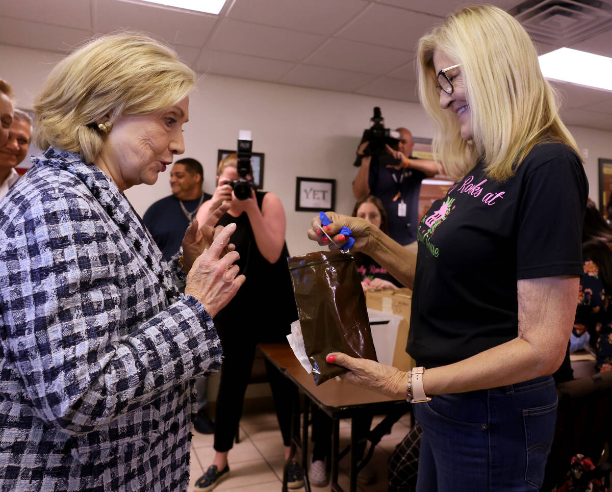 Former Secretary of State Hillary Clinton, left, checks out an overdose rescue kit with volunte ...