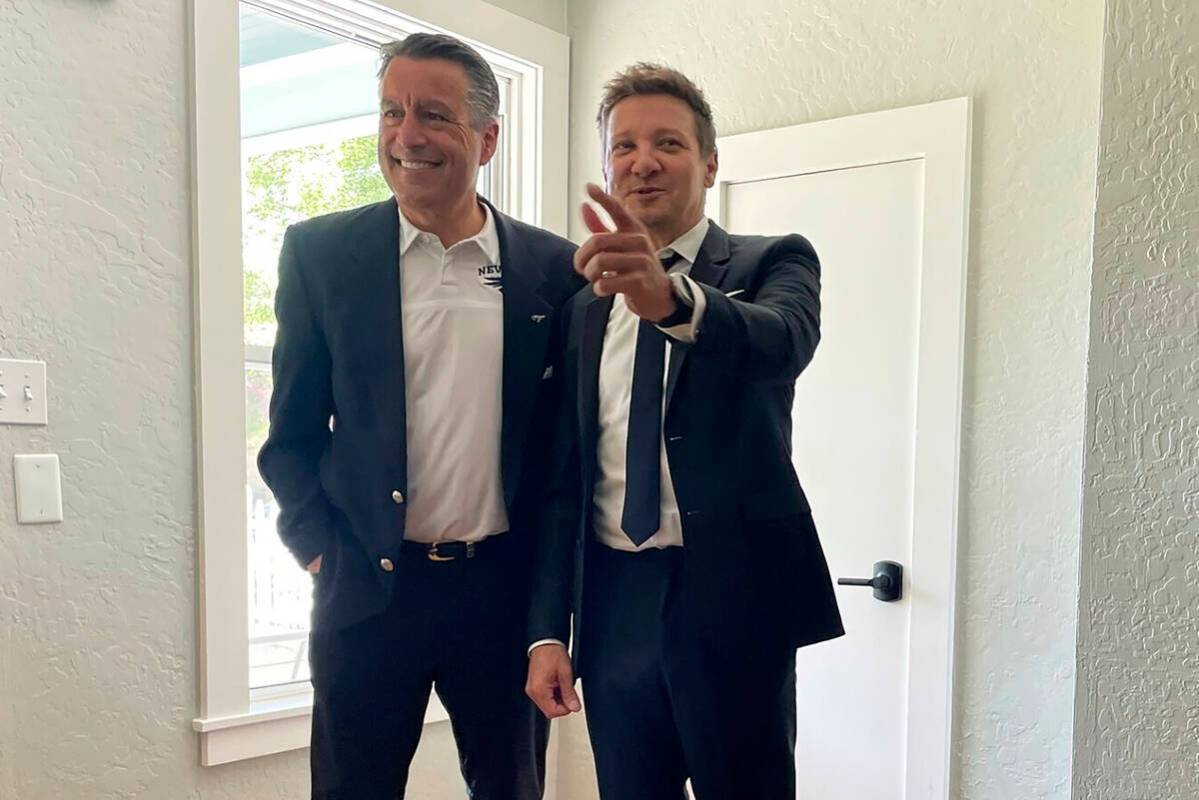 Actor Jeremy Renner, right, poses for a photo with former Nevada Gov. Brian Sandoval, now presi ...
