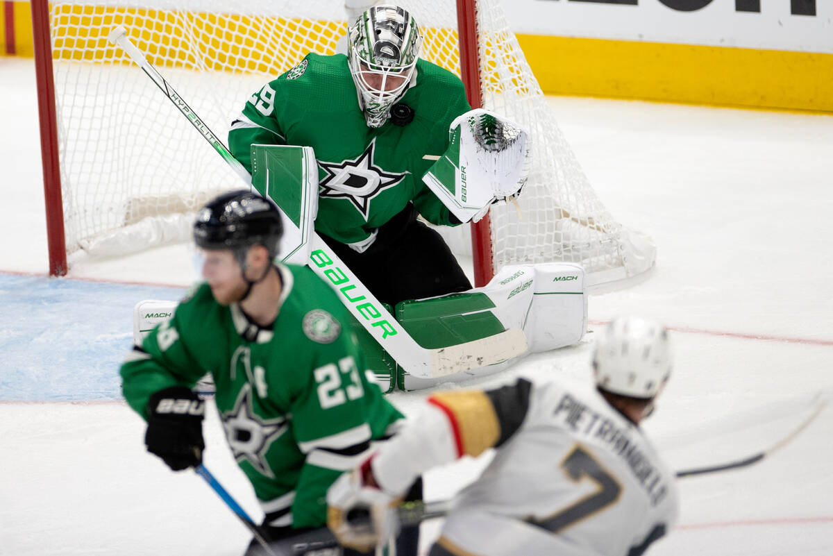 Dallas Stars goaltender Jake Oettinger (29) saves the puck from a shot by Golden Knights defens ...