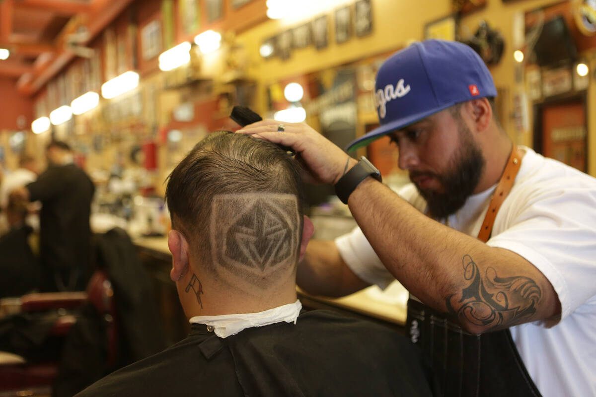 Moises “Moy The Barber” Alvarez, right, owner of the Goodtimes Barber Shop & ...