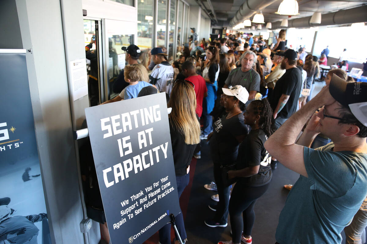 Fans watch the Vegas Golden Knights practice from a hallway after seating was at maximum capaci ...