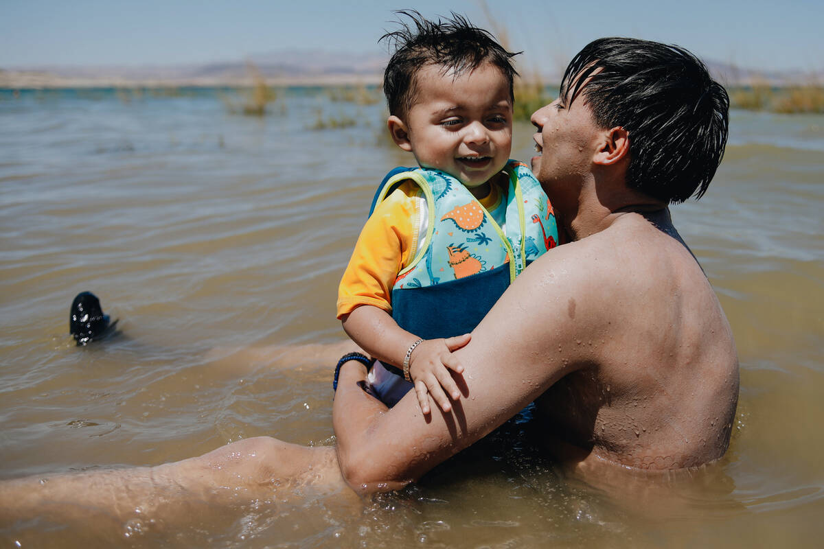 Ricardo Velasquez holds his son, Azael Velazquez, 1, in the water on Sunday, May 28, 2023, at L ...