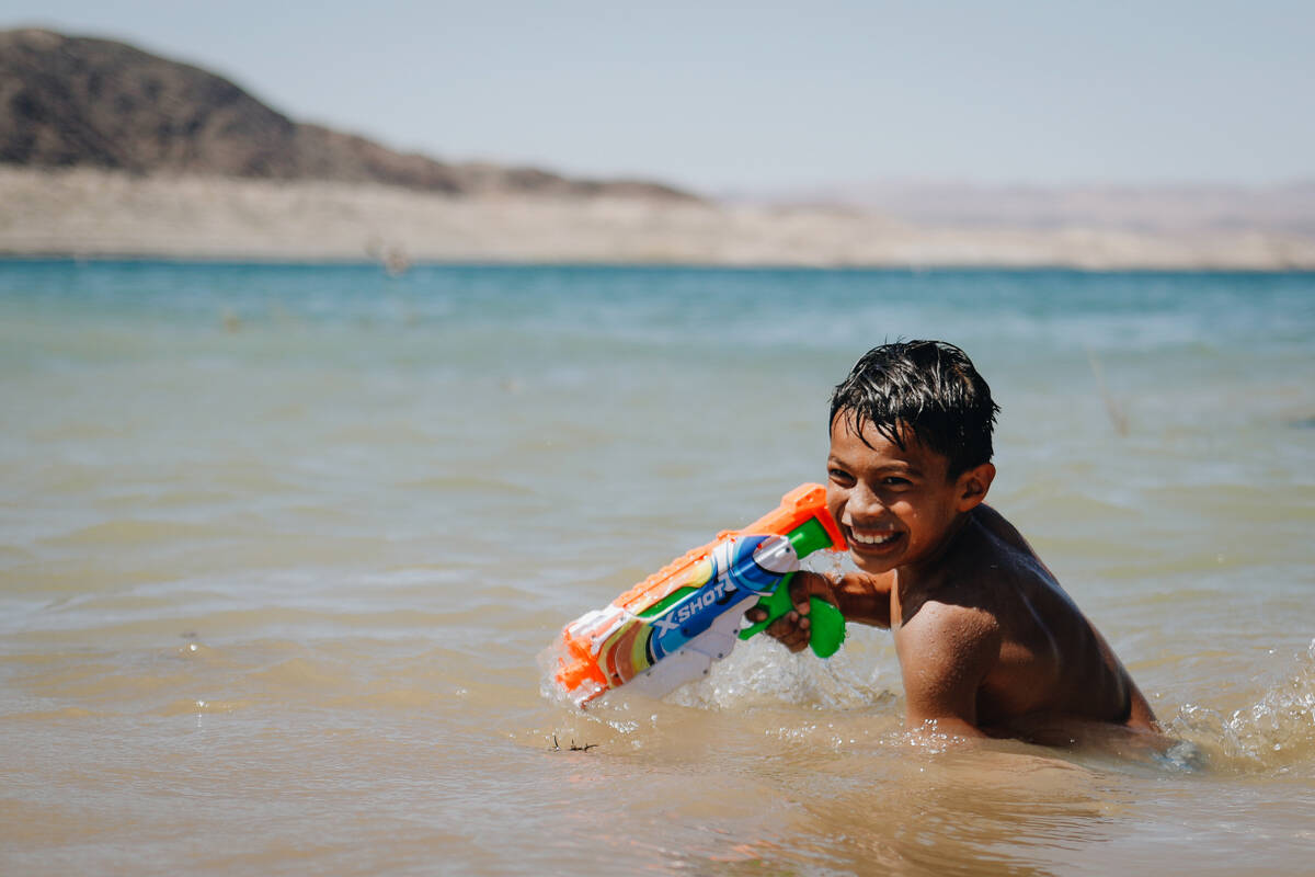 Armando Tirre III, 8, laughs as he carries around a water gun in the water on Sunday, May 28, 2 ...