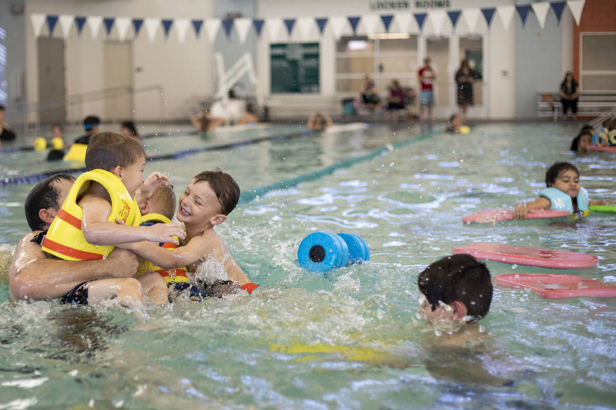 Paul Brinkerhoff, of Henderson, plays with his sons Evan Brinkerhoff, 8, right, and Easton Brin ...