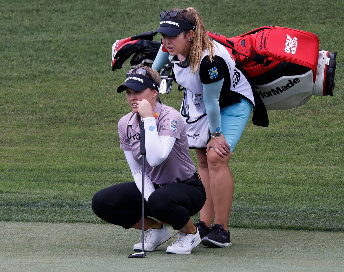 Brooke Henderson of Canada, left, lines up a putt with her caddie on the 12th green during the ...