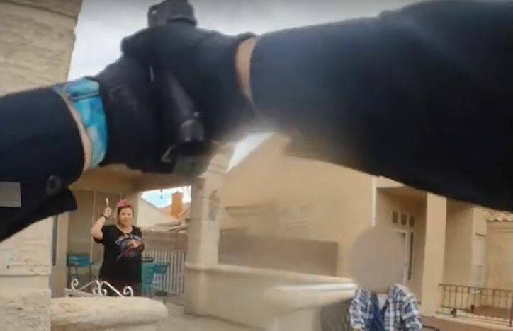 Officer Caitlyn Ebert points her gun at Felicia Guzman who walks toward officers holding up a b ...