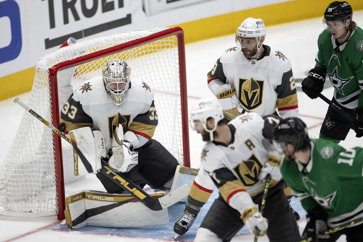 Golden Knights goaltender Adin Hill (33) saves the puck while defenseman Alex Pietrangelo (7), ...