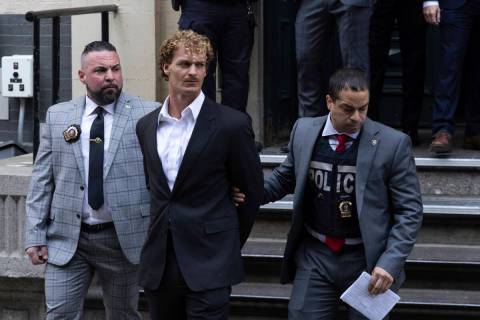 Daniel Penny, center, is walked by New York Police Department detectives detectives out of the ...