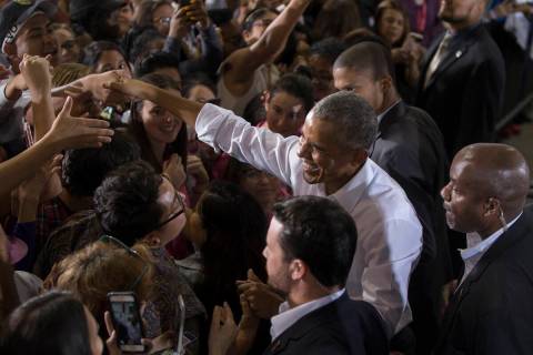 Former President Barack Obama, right, shakes hands with the crowd at Cox Pavilion after a rally ...