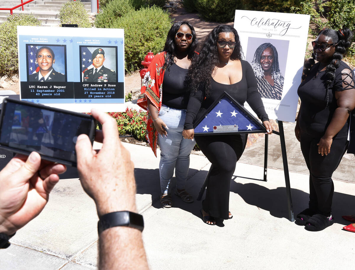 Arrianna Savage, left, her sisters Micah King, and Nia, right, pose for a photo in front of the ...
