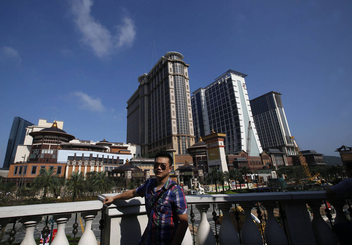A visitor poses in front of the Sands' newest integrated resort, Sands Cotai Central, in Macau ...