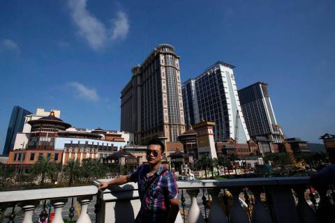 A visitor poses in front of the Sands' newest integrated resort, Sands Cotai Central, in Macau ...