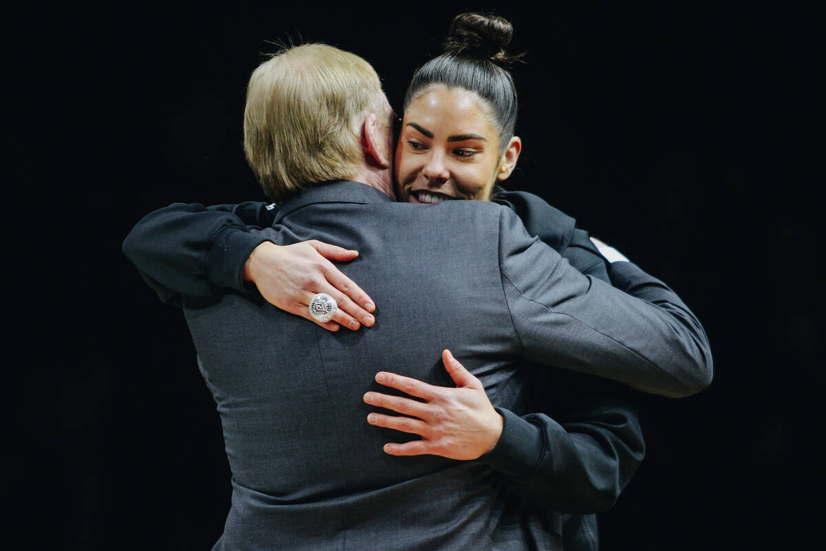 Las Vegas Aces guard Kelsey Plum hugs Aces owner Mark Davis after receiving her championship ri ...