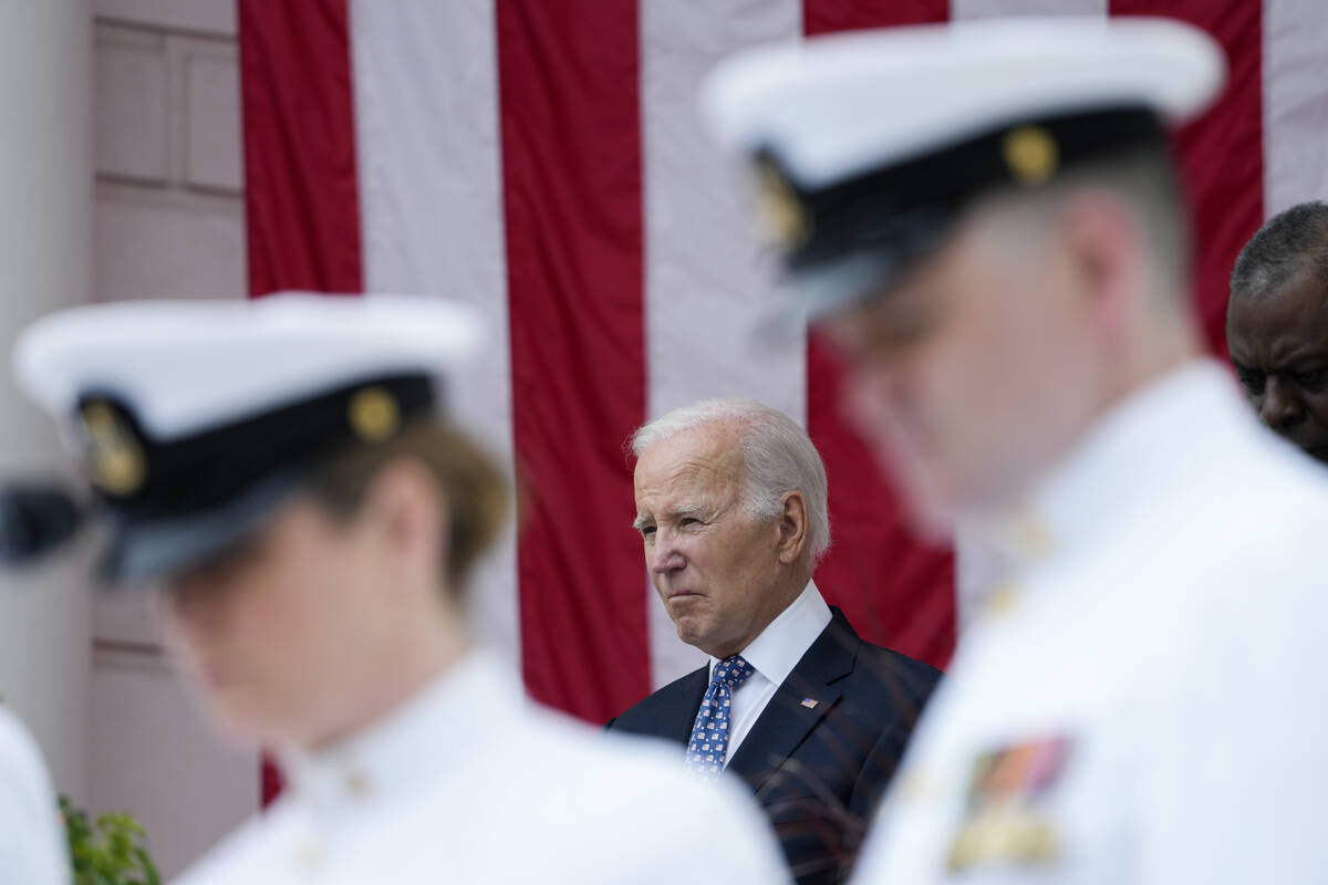 President Joe Biden stands with Defense Secretary Lloyd Austin as the national anthem is played ...