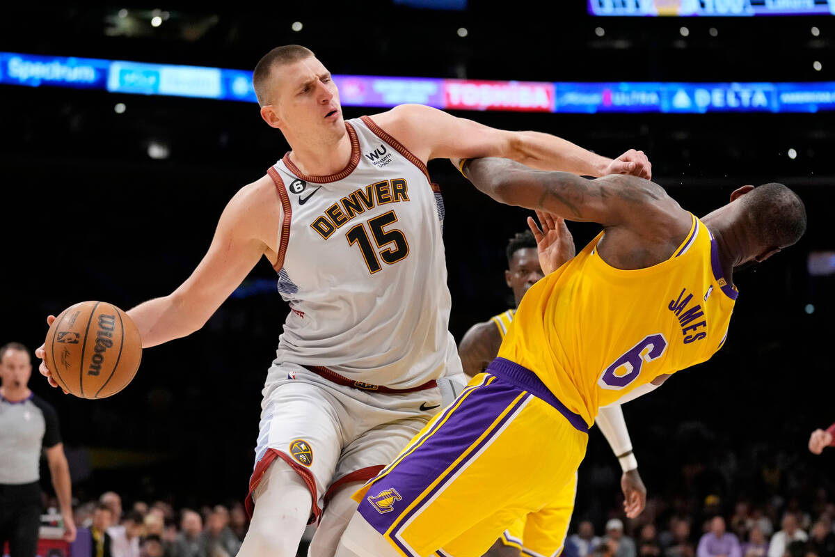 Denver Nuggets center Nikola Jokic (15) collides with Los Angeles Lakers forward LeBron James ( ...
