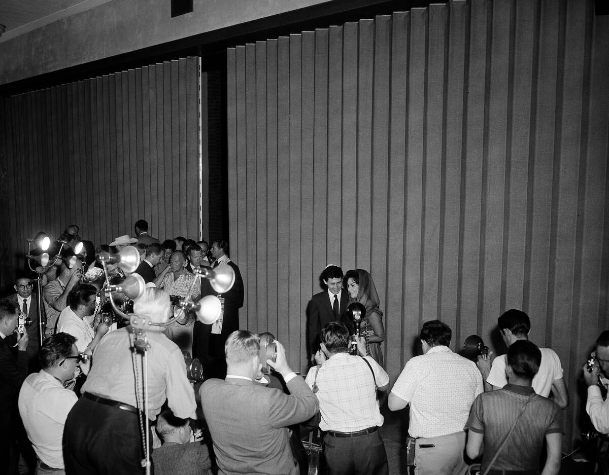 A pair of famous hand holders, Elizabeth Taylor and Eddie Fisher, poses on the stage of the Tro ...