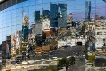 The parking lot and architecture beyond including parts of the Strip reflected in the glass on ...