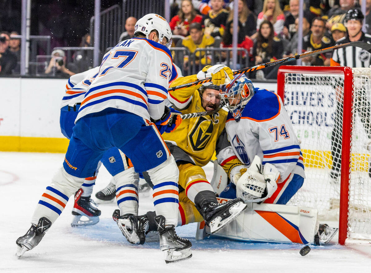 Golden Knights right wing Mark Stone (61) is pushed on a shot by Edmonton Oilers defenseman Bre ...