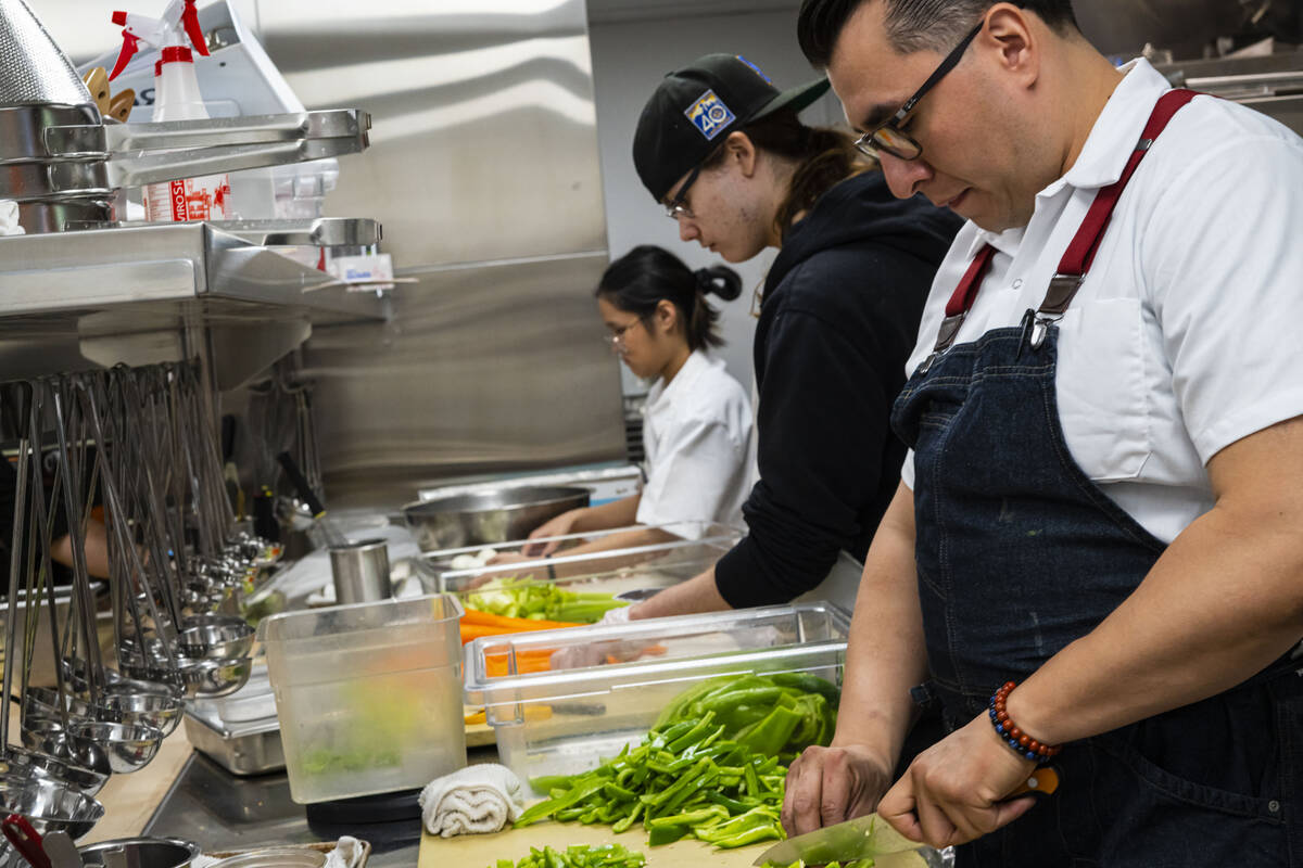 La Krishna David, left, prep cook, and Chris Simmons help Executive Chef Alexander Huizar prepa ...