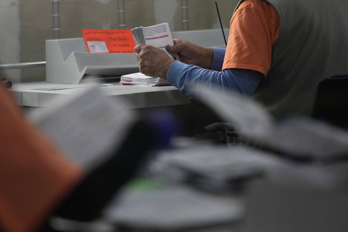 An election worker prepares mail-in ballots at the Clark County Election Department on Tuesday, ...