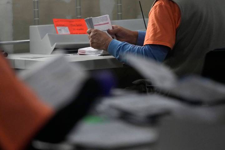 An election worker prepares mail-in ballots at the Clark County Election Department on Tuesday, ...