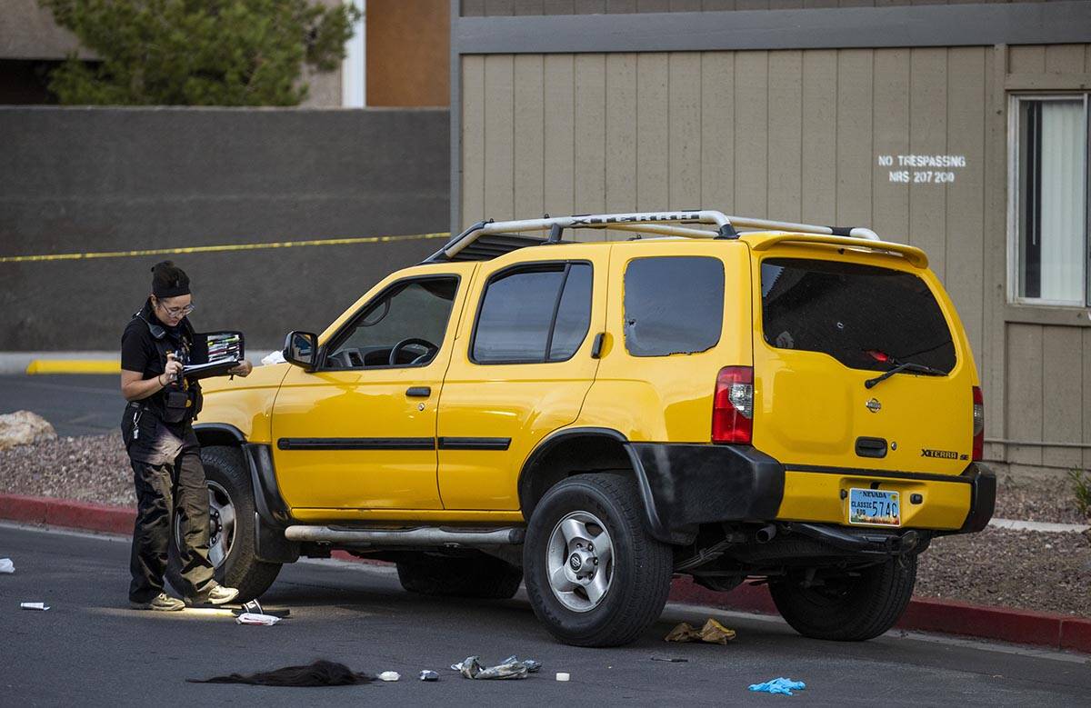 A Metro crime scene analyst works the scene of a homicide at the Solaire East Apartments on Sat ...